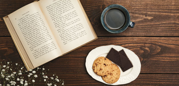 お菓子とコーヒーと本の写真