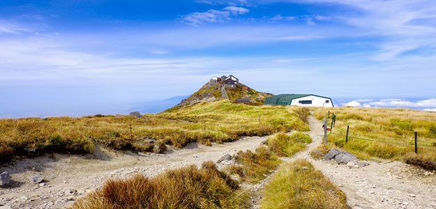 青空と山頂の山小屋の写真