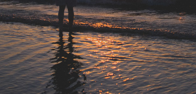 夕暮れの海と人影の写真