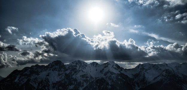 山の上で輝く太陽の写真