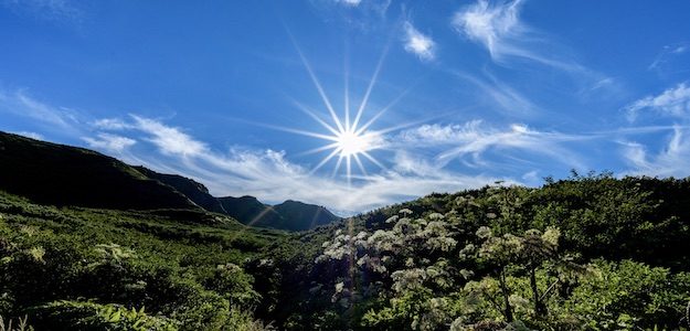 光芒の太陽と山の写真